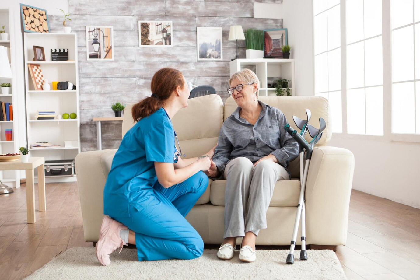 Elderly woman with crutches conversing with friendly nurse