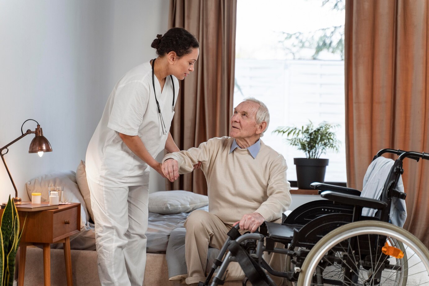 Caregiver helping elderly man from wheelchair supportively